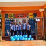 propietarios y empleados de la agencia con sus camisetas de la selección y globos celestes posan frente a la agencia
