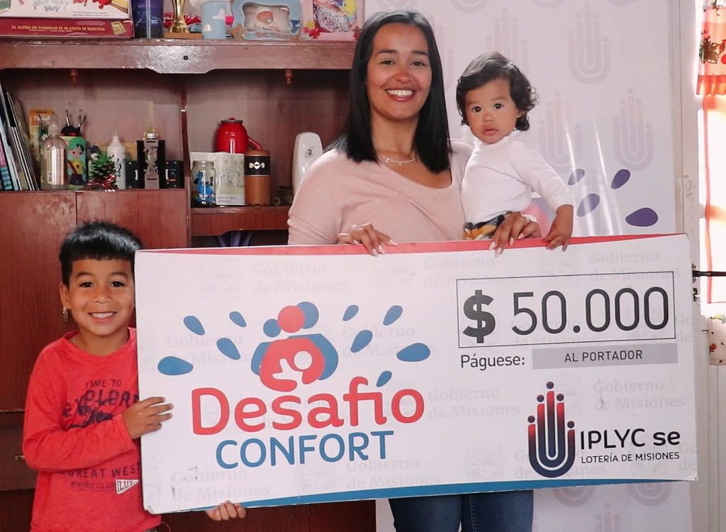 ganadora recibe el cheque con sus dos hijos