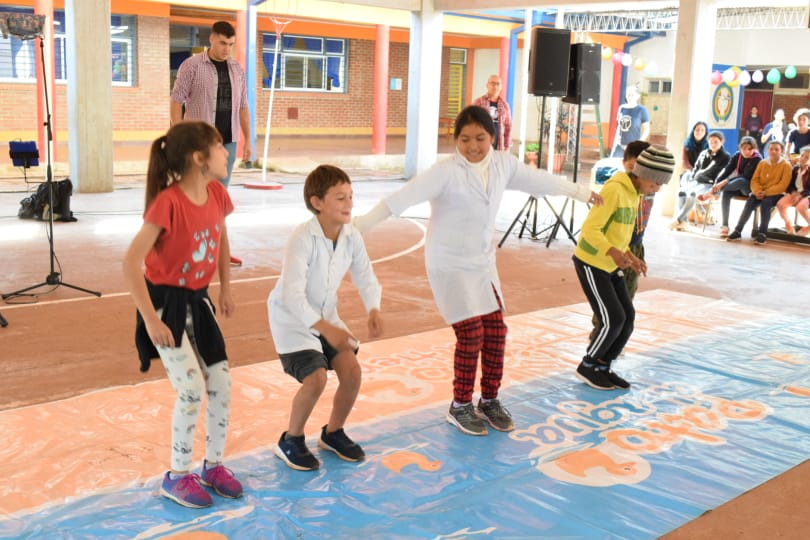 4 niños saltando sobre un juego de patio