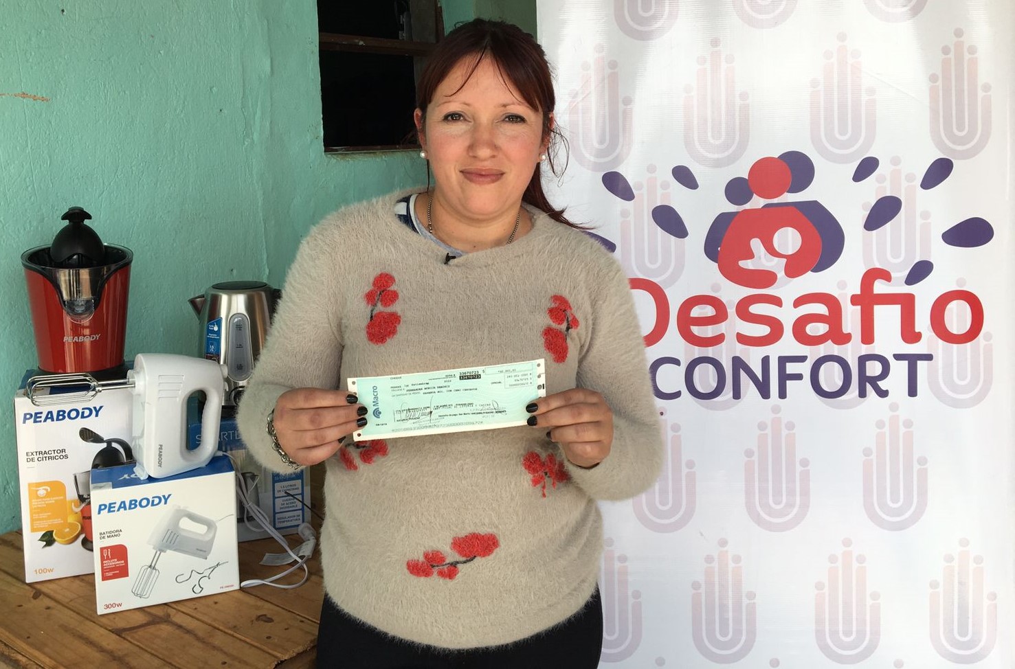 Mónica Fernández mostrando su cheque y los demás premios recibidos