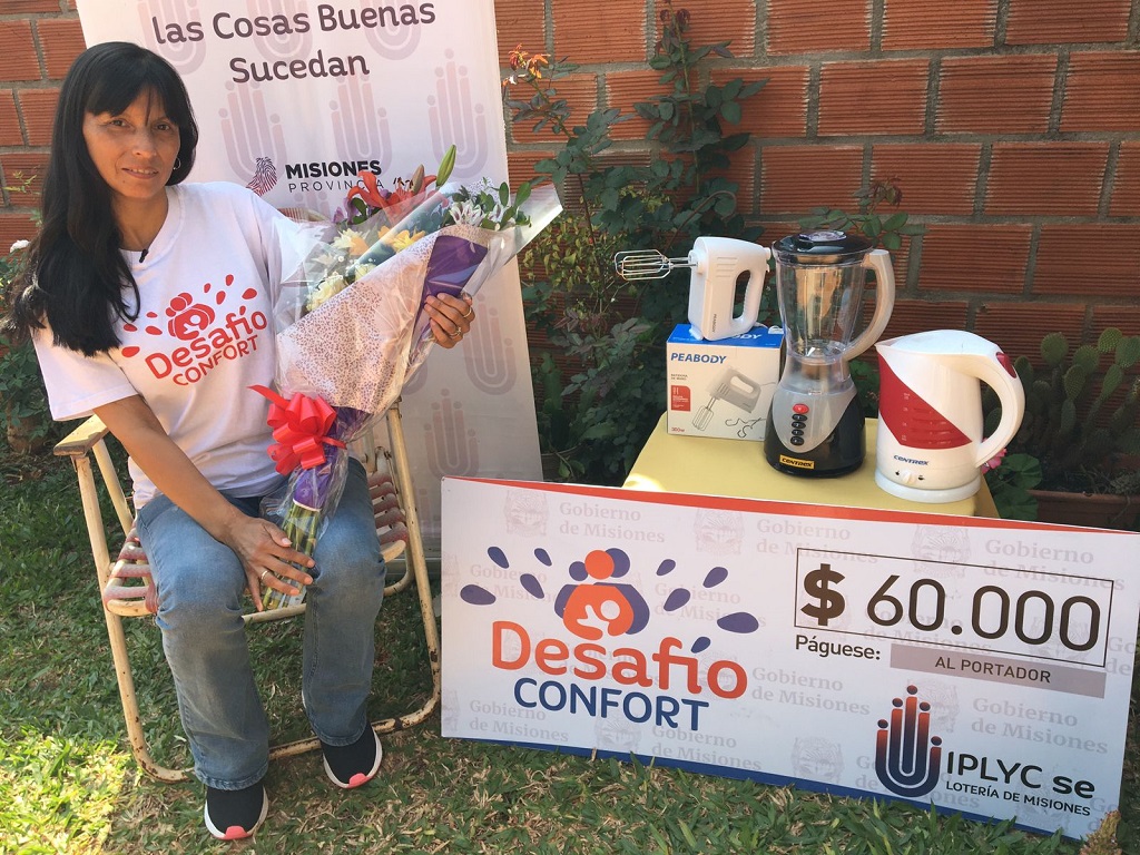 Lidia Balbuena con su cheque y premios sosteniendo un ramo de flores