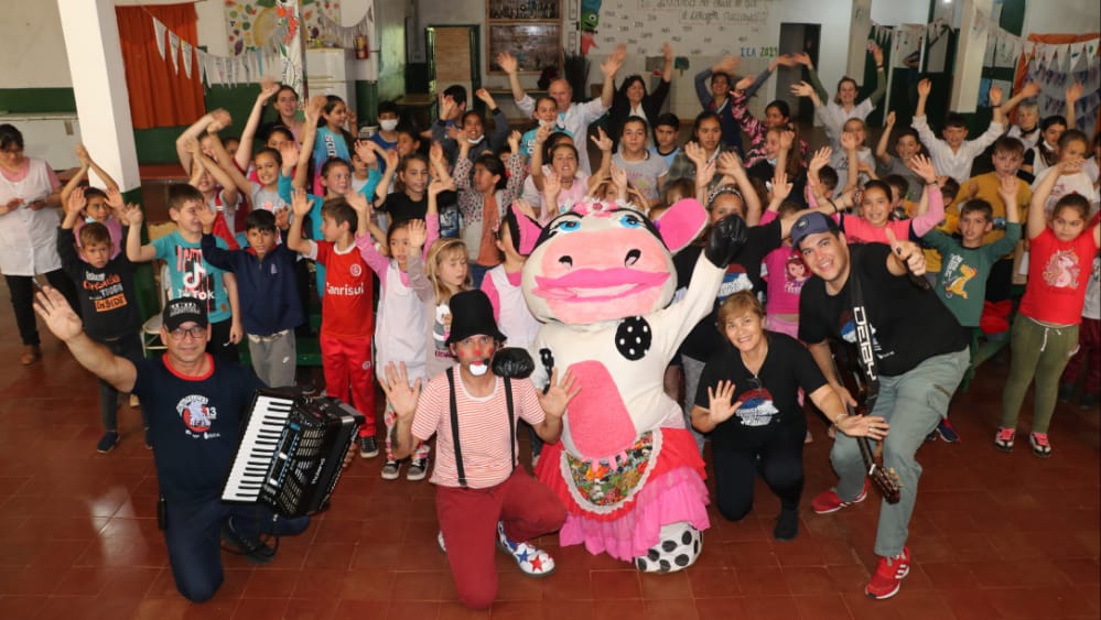 selfie de la Vaca Lola con el equipo de Gurises y los niños, maestros y personal de la escuela