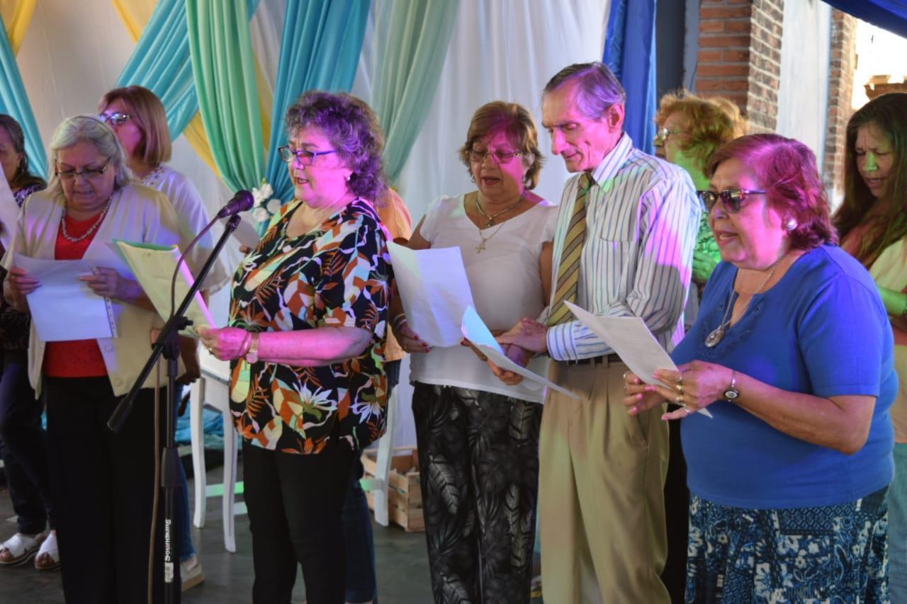 grupo de abuelos cantando frente a un micrófono
