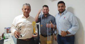 tres integrantes de la delegación muestran sus medallas y trofeos