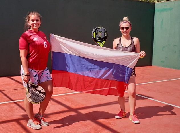 dos jugadoras de pádel sostienen la bandera de Misiones