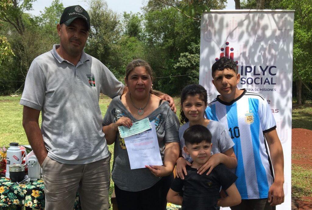 Valeria Insaurralde junto a su familia muestra su cheque