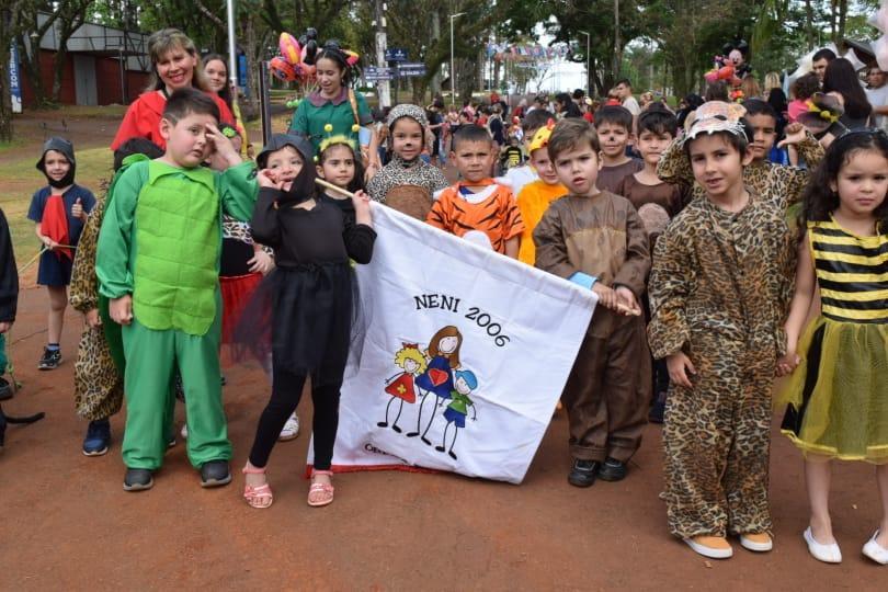 los niños con sus disfraces de distintos animalitos muestran su estandarte del jardín