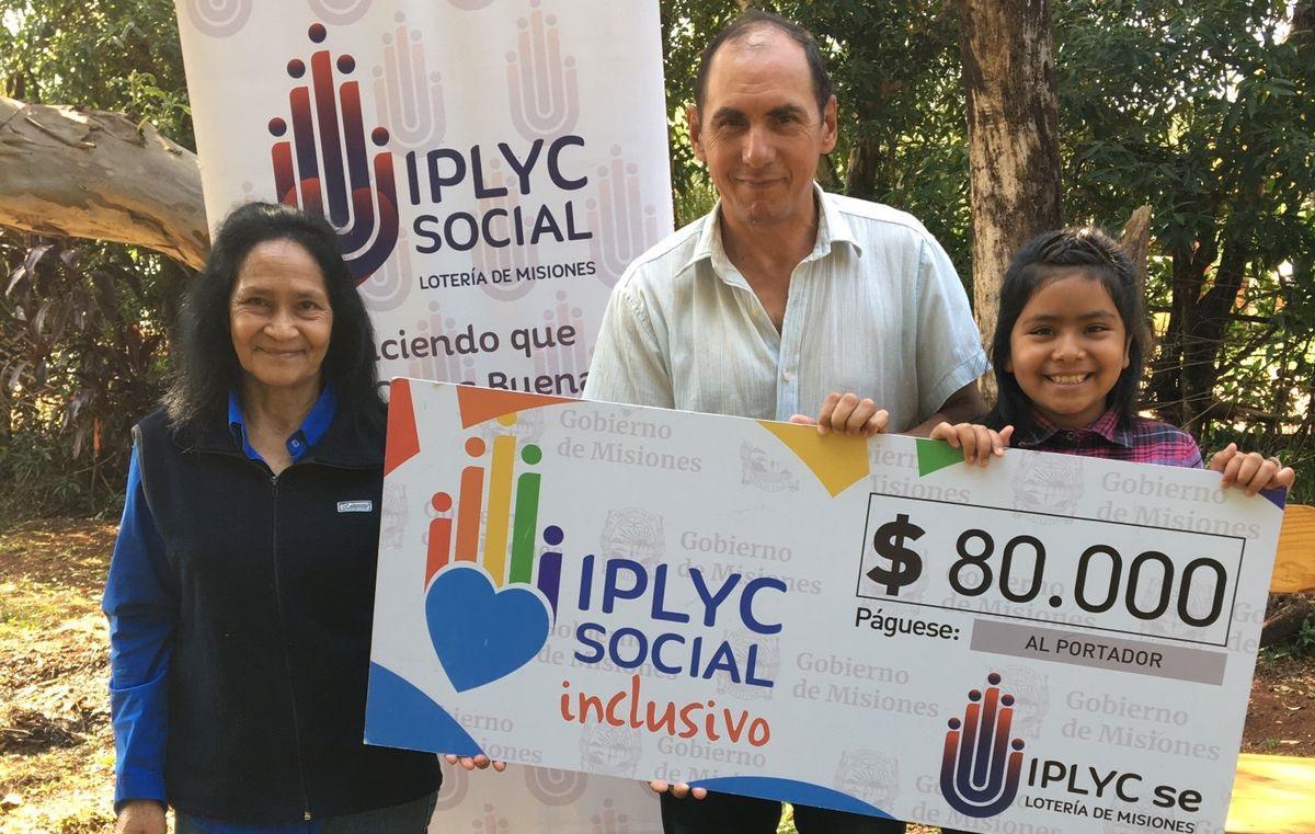 Héctor Metrechen junto a su esposa e hija, muestran su cheque