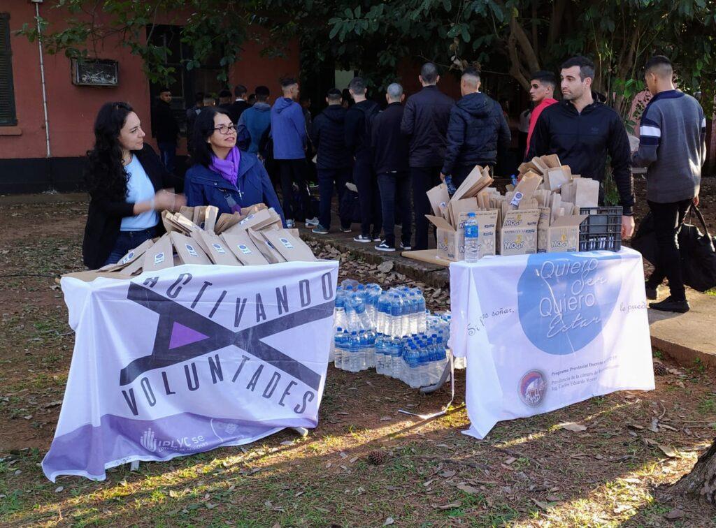 Mabel Pezoa y voluntarios entregan a los ingresantes agua y golosinas para el viaje.