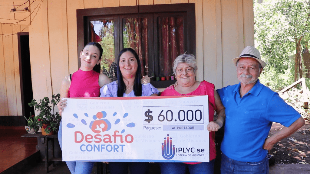Janina Céspedes junto a su familia muestra su cheque