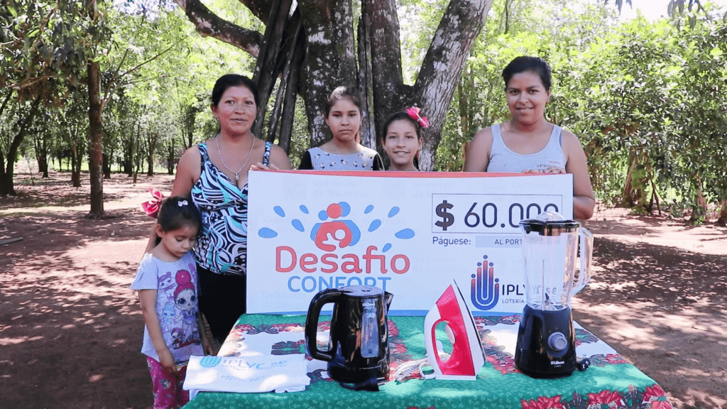 Tiburcia Espínola Duarte muestra su cheque junto a su familia