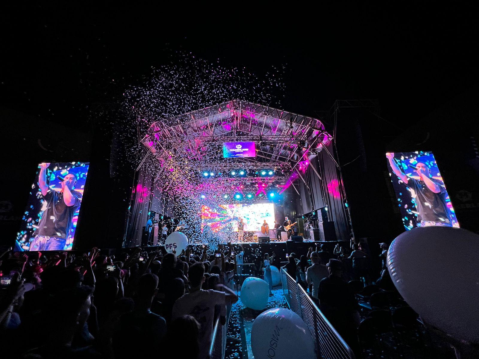 FMK canta sobre el escenario con una lluvia de papelitos sobre el público