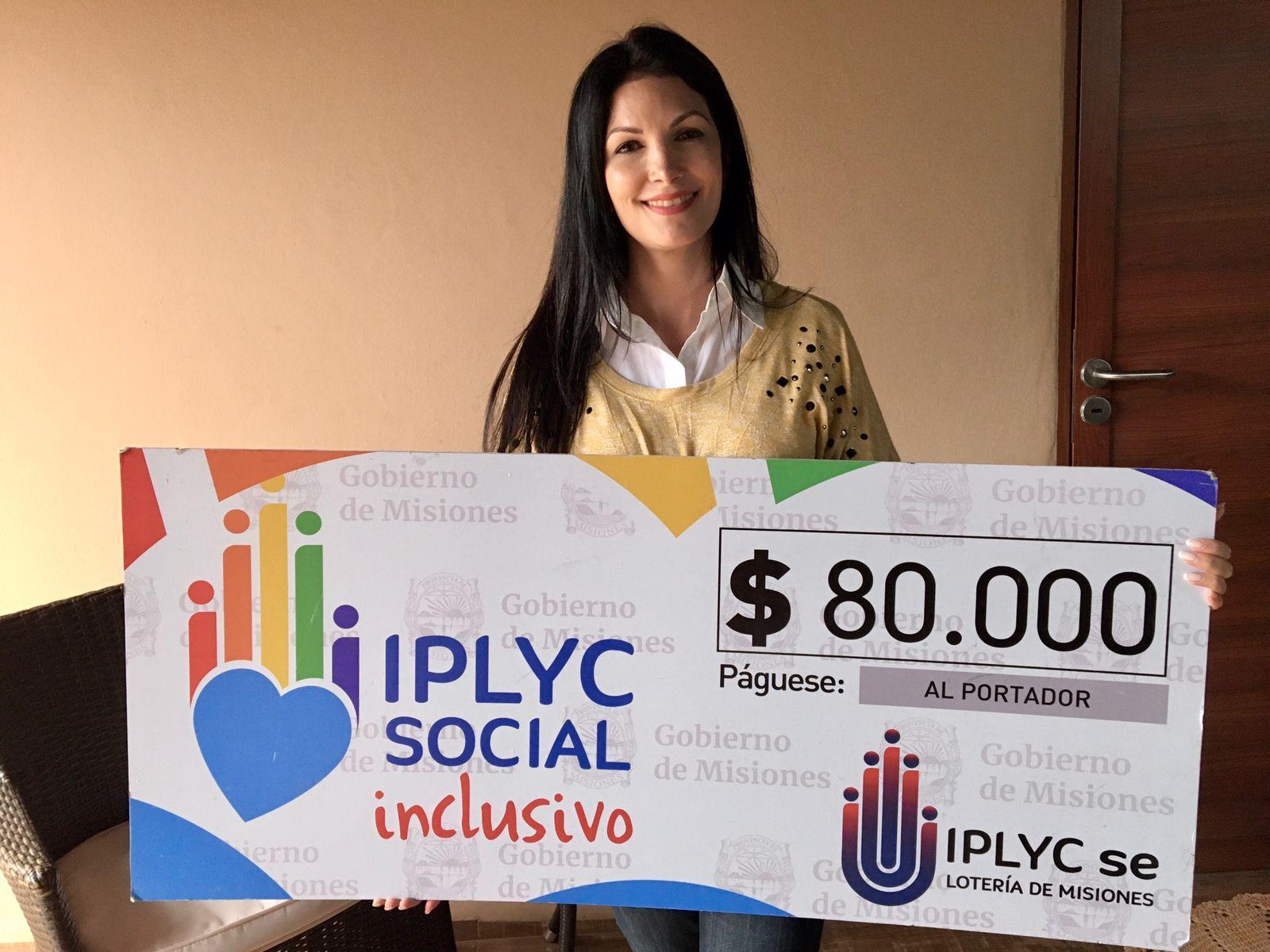 Noelia Rogoski muestra el cheque de IPLyC Social Inclusivo