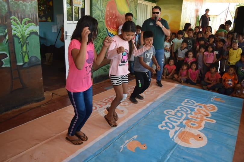 Marcelo Ledesma alienta a tres niños que participan de un juego de piso