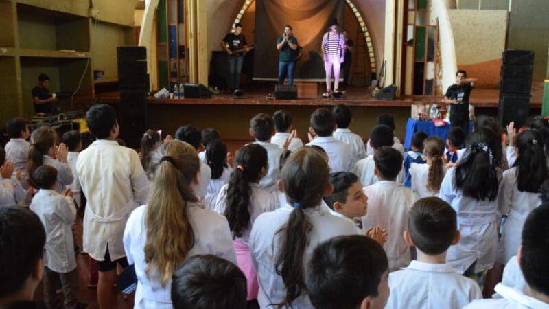 Equipo de Gurises Felices sobre el escenario frente a los niños de la escuela de Alem