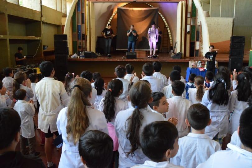 Equipo de Gurises Felices sobre el escenario frente a los niños de la escuela de Alem