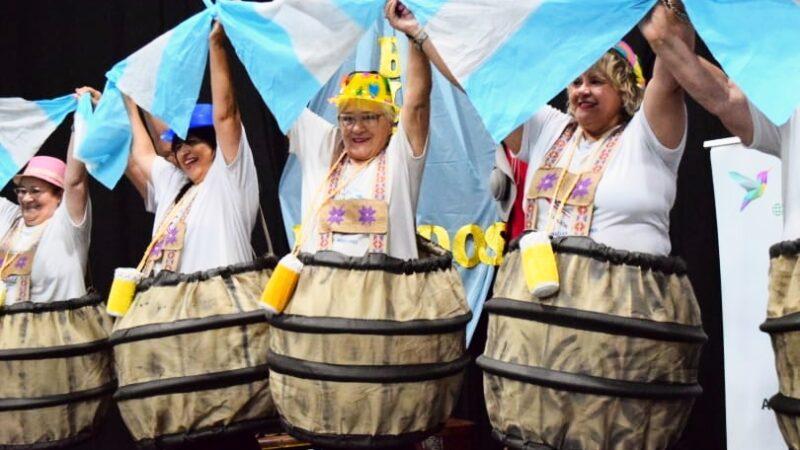 grupo de abuelos vestidos de barrilitos levantan banderas argentinas