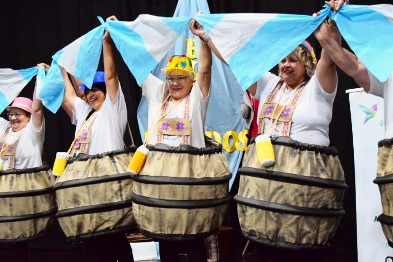 grupo de abuelos vestidos de barrilitos levantan banderas argentinas