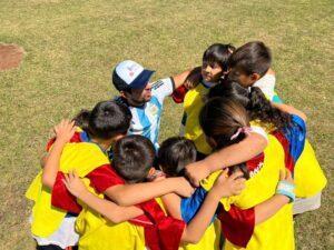 niños abrazados en ronda con colaborador del programa