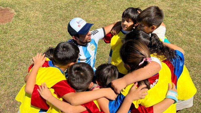 niños abrazados en ronda con colaborador del programa