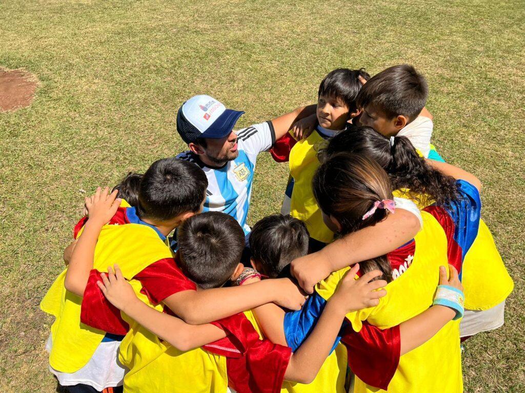 niños abrazados en ronda con colaborador del programa