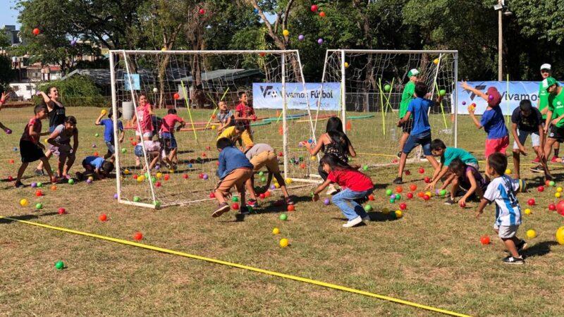 niños jugando con pelotitas de colores y arcos en una cancha