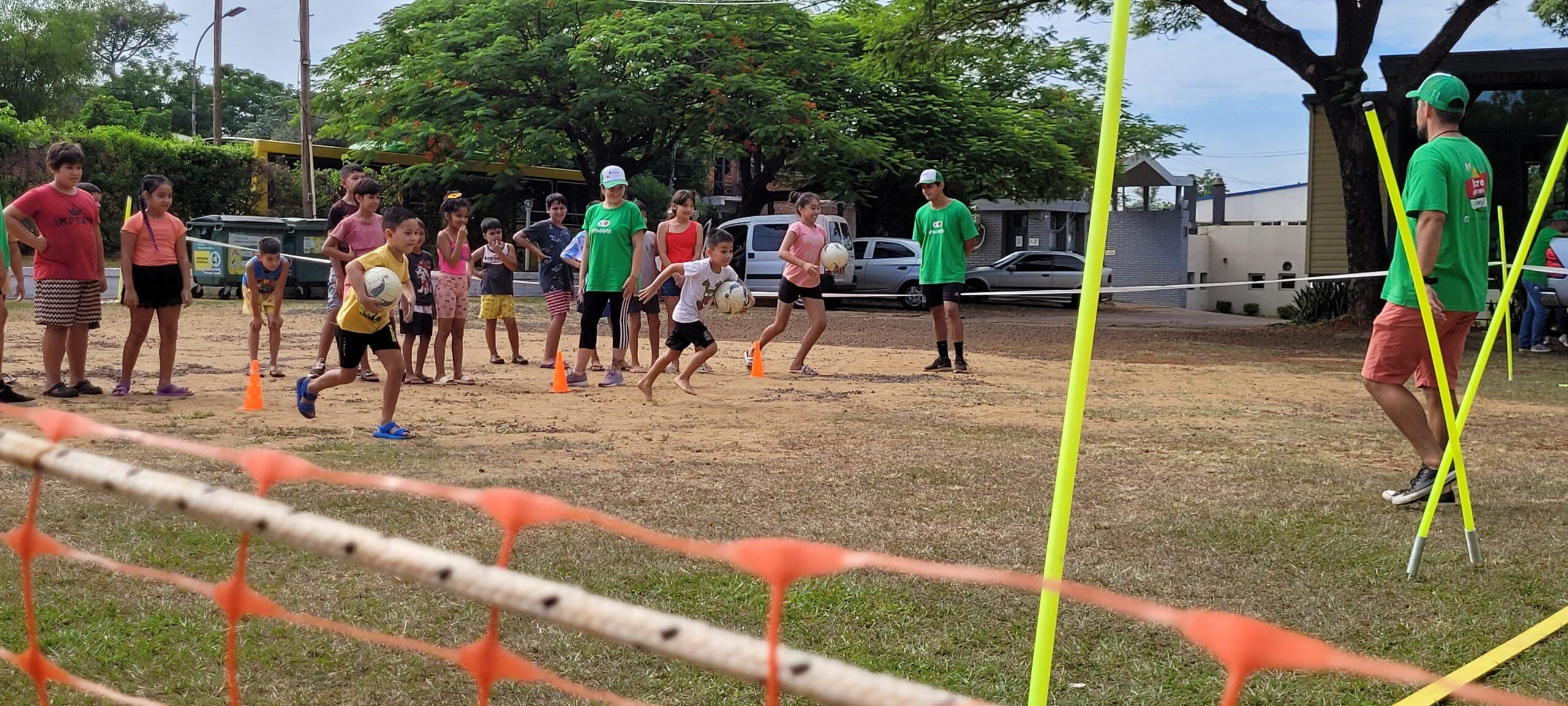 equipos de niños compiten en carrera con pelotas