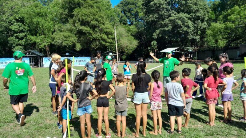 niños en ronda por empezar un juego, escuchan atentos indicaciones del coordinador