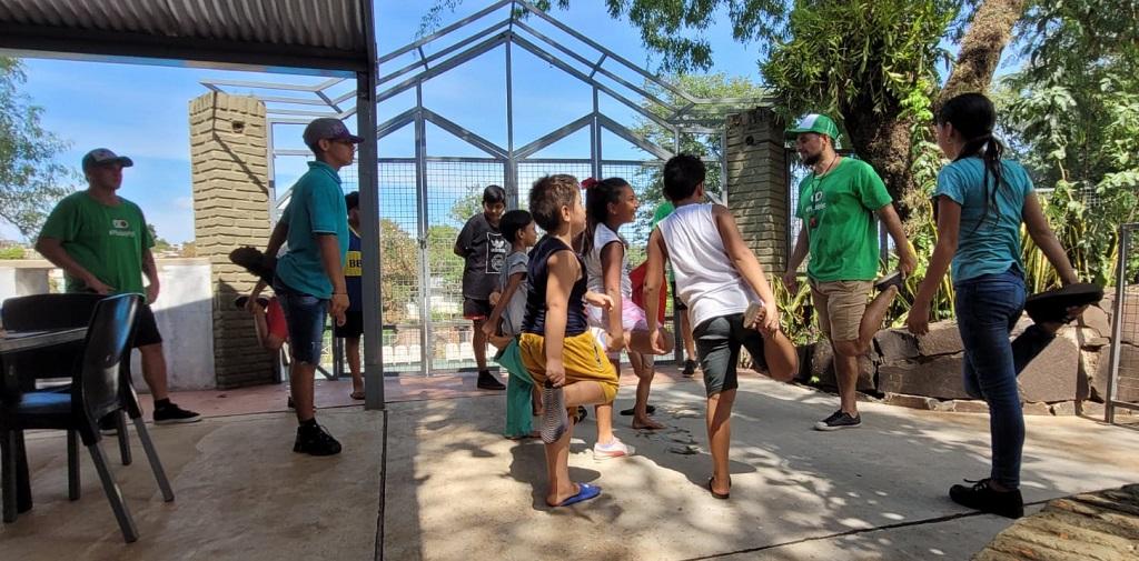 niños elongan una pierna siguiendo indicaciones de integrantes del equipo de Recreo de Verano