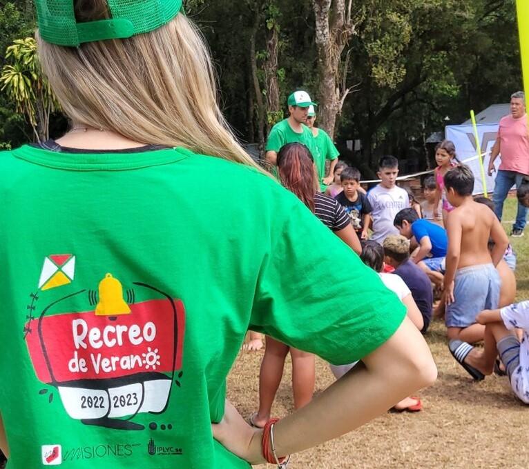 primer plano de espalda de coordinadora que observa a los niños, que muestra remera con logo del programa