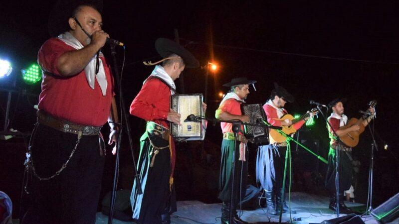 grupo folclórico de 5 integrantes vestidos de gauchos actúa sobre el escenario