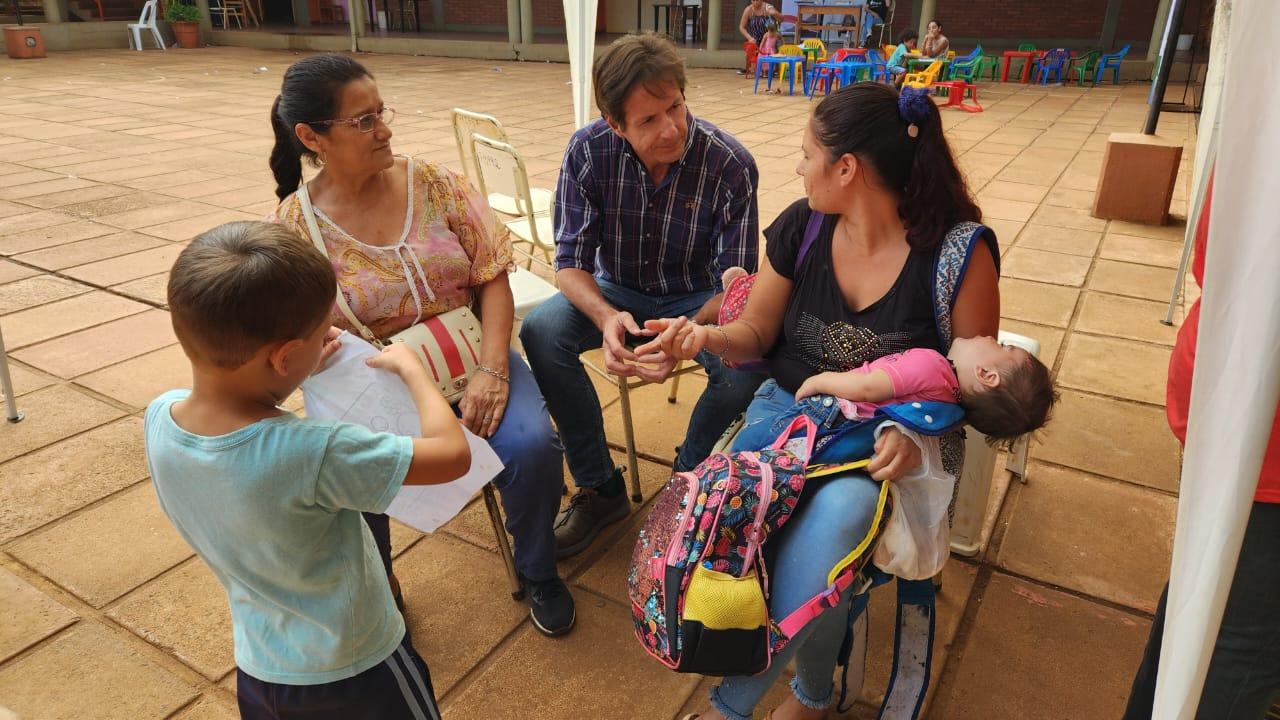 Decut charla con dos mamás con sus hijos en el patio de la escuela