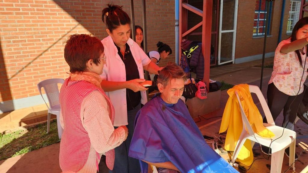 peluquera corta el cabello a un vecino que se acercó al operativo de IPLyC Social Presente.