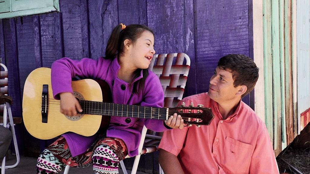 Julia De Olivera toca la guitarra junto a su papá.