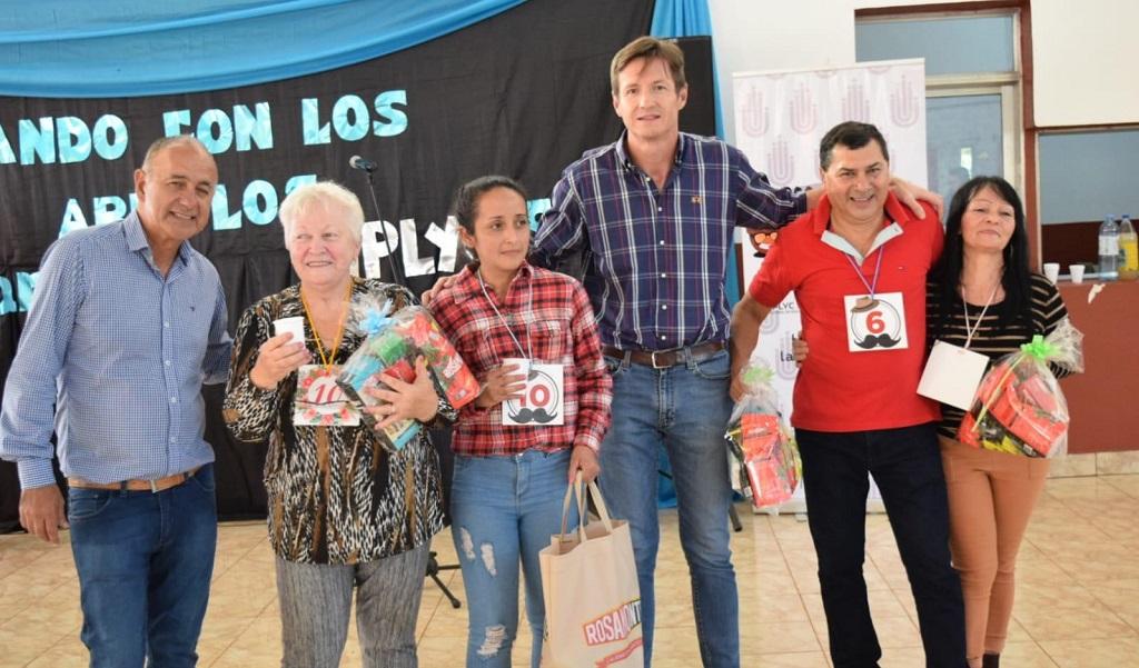 Héctor Decut junto a algunos participantes con sus obsequios de Mateando con los abuelos en Guaraní.