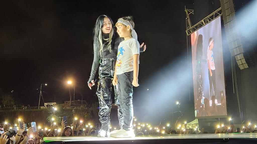 Nicki Nicole junto al niño que invitó a cantar sobre el escenario.