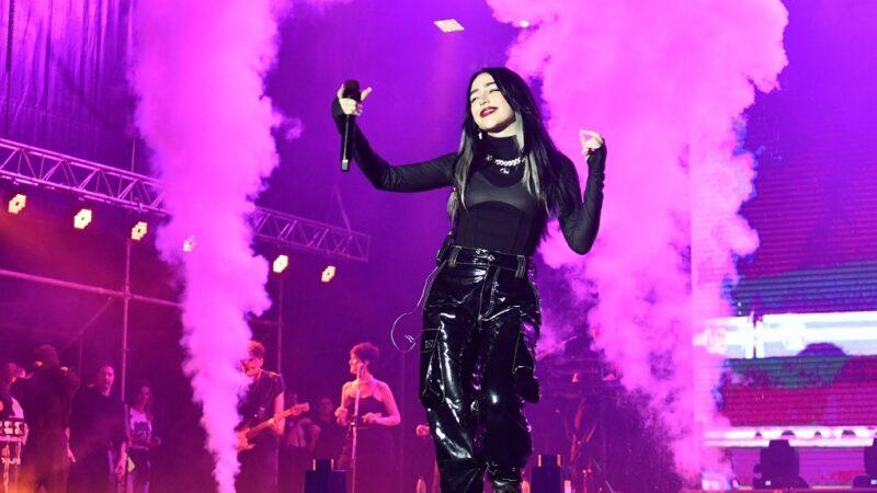 Nicki Nicole en pleno show con su banda y bailarines.
