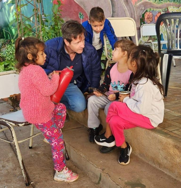 Héctor Decut charla con 4 niños que asistieron al operativo.
