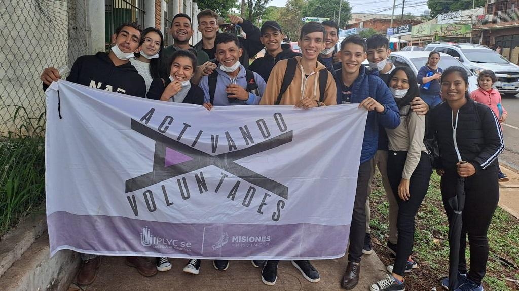 grupo de jóvenes ingresantes sostienen la bandera de Activando Voluntades.