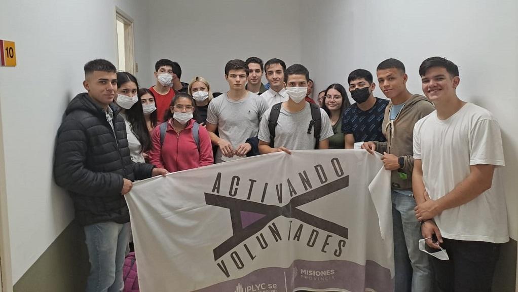 grupo de jóvenes ingresantes sostienen bandera de Activando Voluntades.