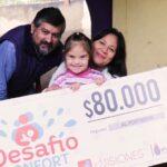 Elida junto a su esposo y su hija muestran felices su cheque del premio de Desafío Confort.