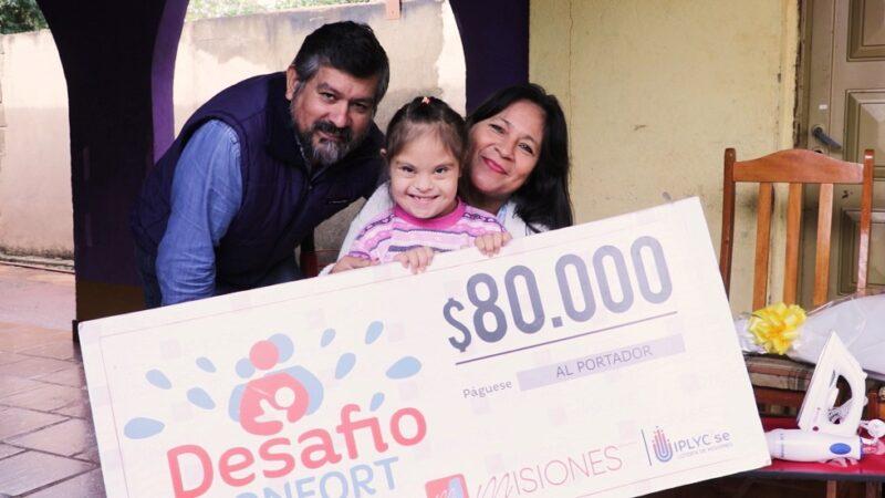 Elida junto a su esposo y su hija muestran felices su cheque del premio de Desafío Confort.