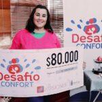 Romina Giménez, ganadora del premio de Desafío, muestra sonriente su cheque.