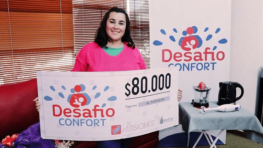 Romina Giménez, ganadora del premio de Desafío, muestra sonriente su cheque.