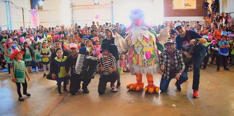 selfie equipo de Gurises Felices y niños saludando.