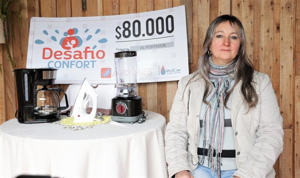 Norma Balanda, ganadora de Desafío Confort, muestra su cheque y electrodomésticos. usará el premio para terminar su casa.