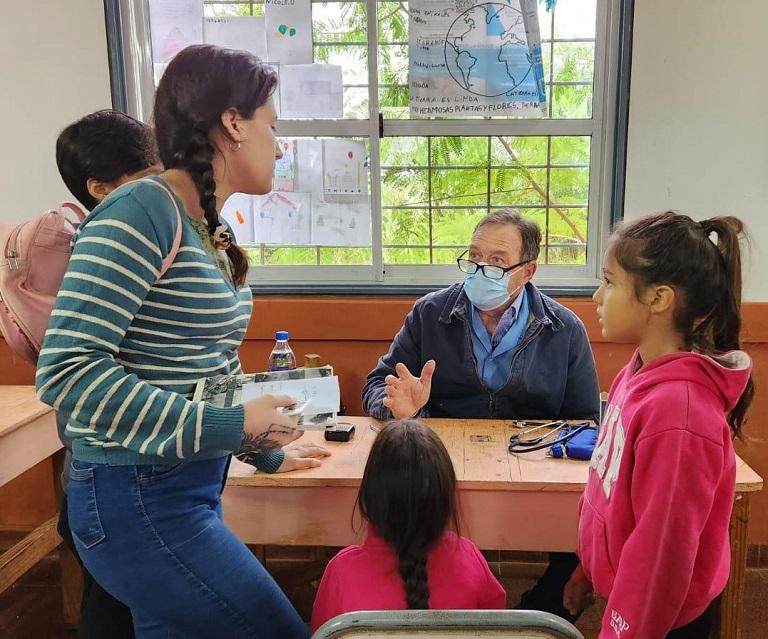 Médico atiende a vecina que se acercó con sus tres hijos para control pediátrico.