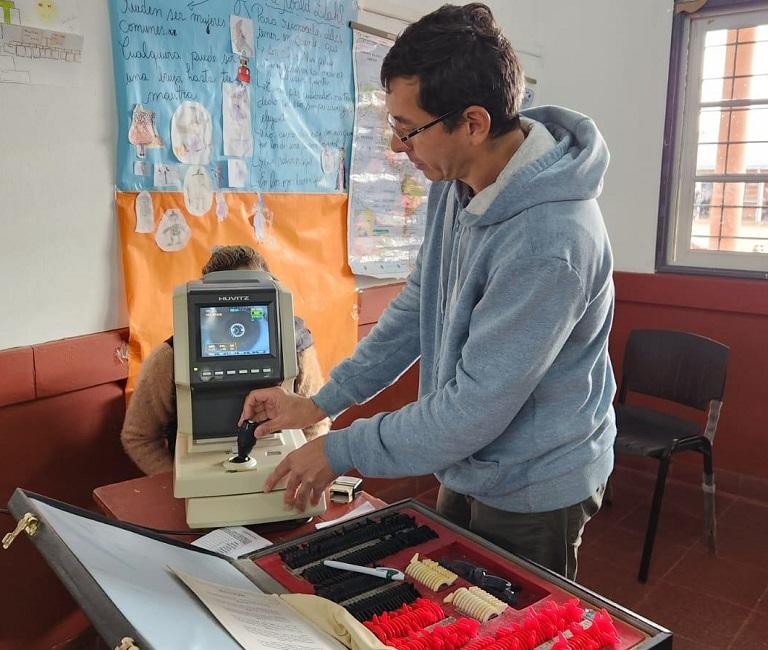 Oftalmólogo con su equipamiento realiza control a una vecina durante el operativo de IPLyC Social Presente.