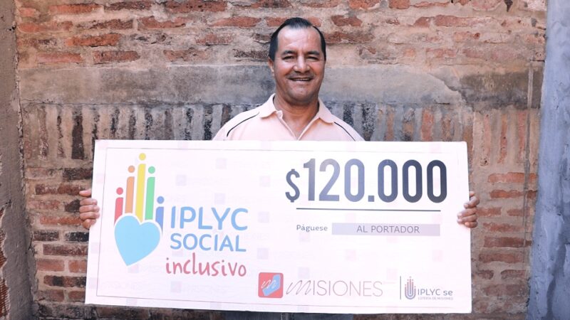 Alfonso Velozo, ganador del premio del Inclusivo, muestra sonriente su cheque.