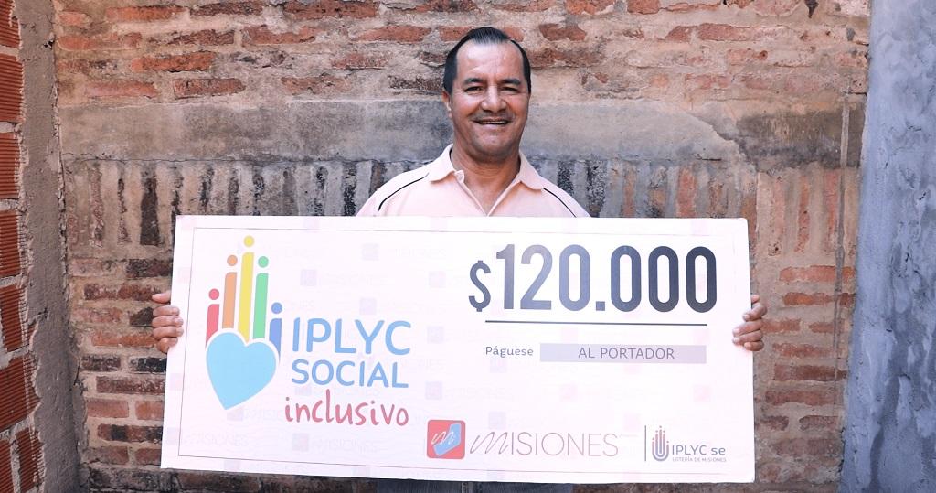 Alfonso Velozo, ganador del premio del Inclusivo, muestra sonriente su cheque.